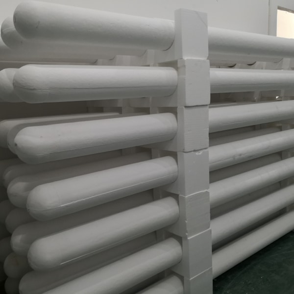 Stacked ceramic fiber filter tubes ready for shipment, showing the flanged tube ends
