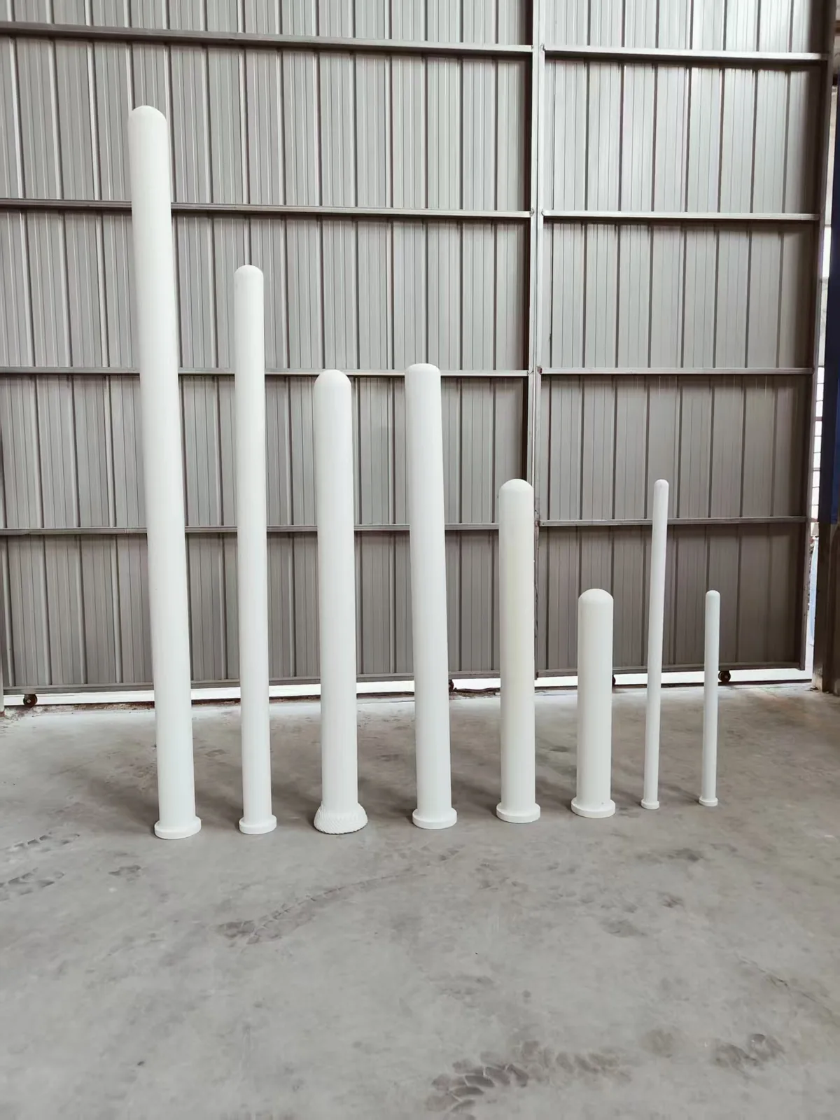 Ceramic fiber filter candle tubes of different diameters standing in a factory workshop